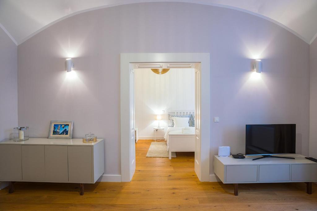 a white living room with a tv and a couch at Deluxe Apartment Talia in Zagreb