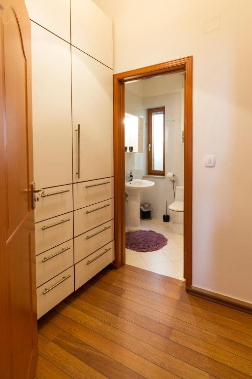 łazienka z toaletą, umywalką i drzwiami w obiekcie Apartment Atlantis w Puli