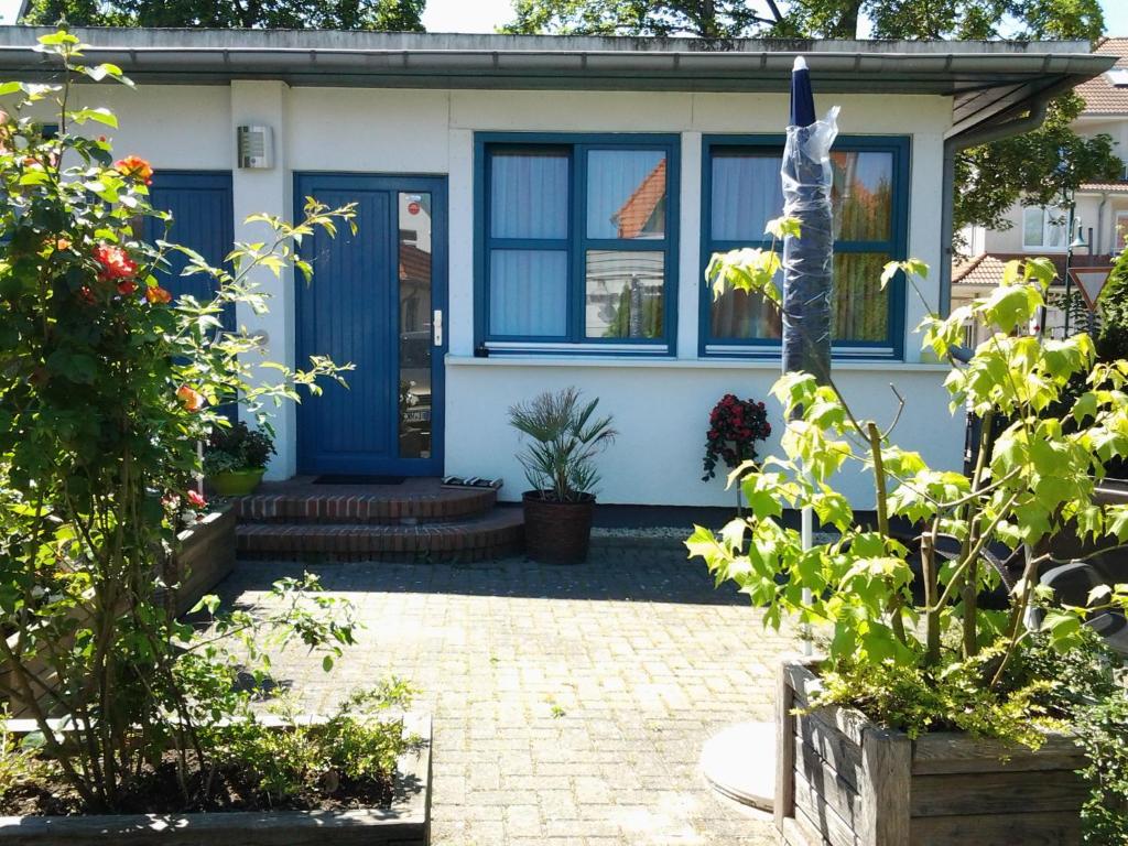 una casa con una porta blu e alcune piante di Fewo Am Kurpark a Boltenhagen