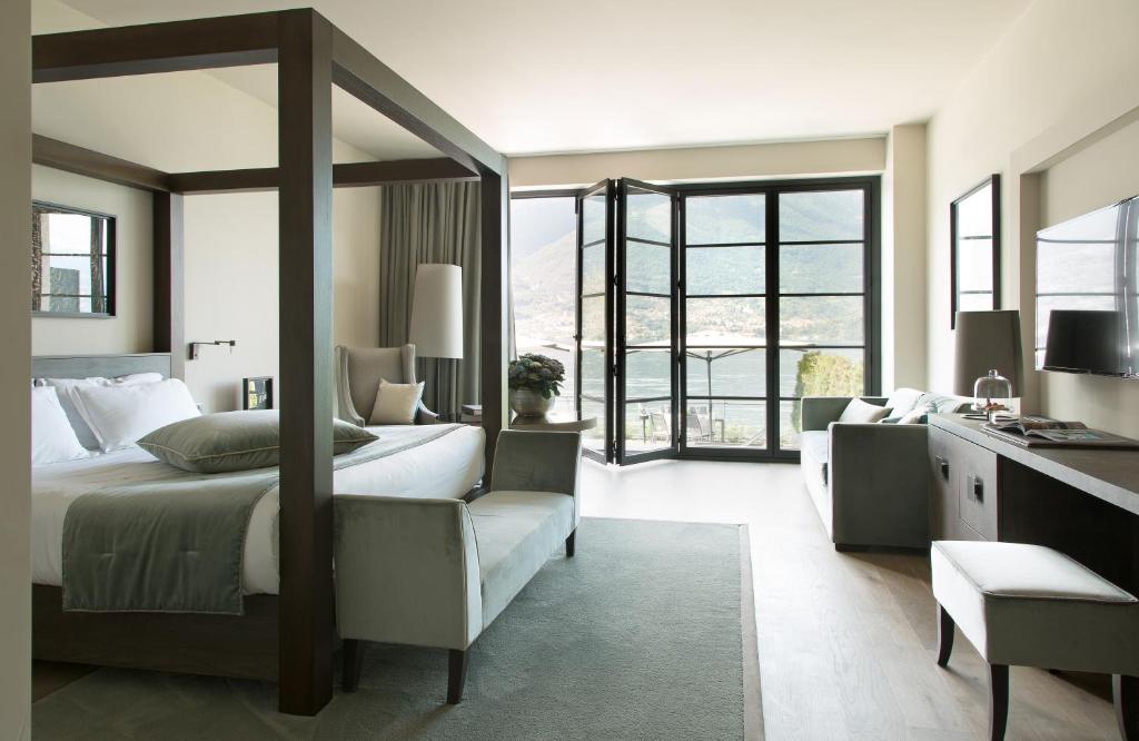 a bedroom with a large bed and a desk at Filario Hotel & Residences in Lezzeno