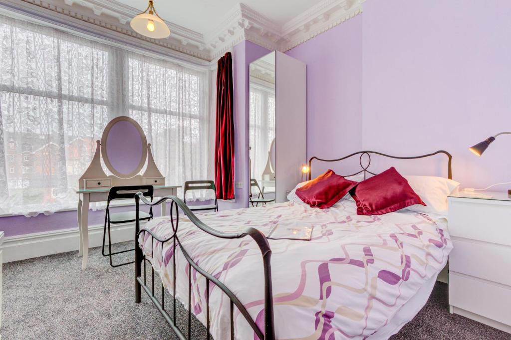 1 dormitorio con cama con espejo y tocador en The Claremont en Lytham St Annes