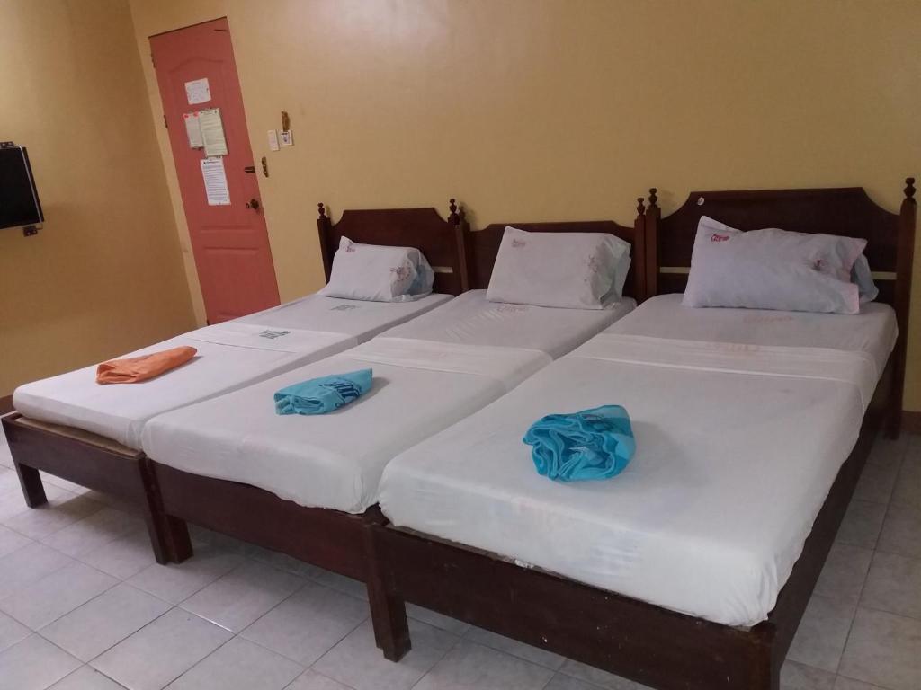two twin beds in a room with blue sheets at Bee Hub Pension in Surigao