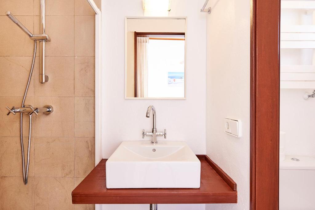a bathroom with a white sink and a shower at Can Mares in Cala Tarida
