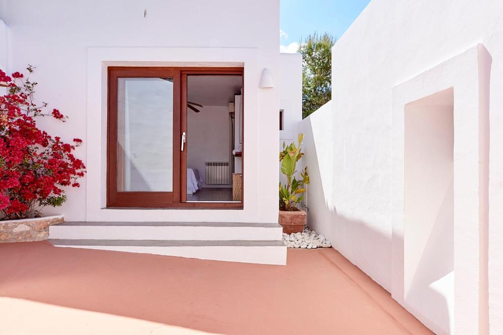 a white house with a window and a courtyard at Can Mares in Cala Tarida