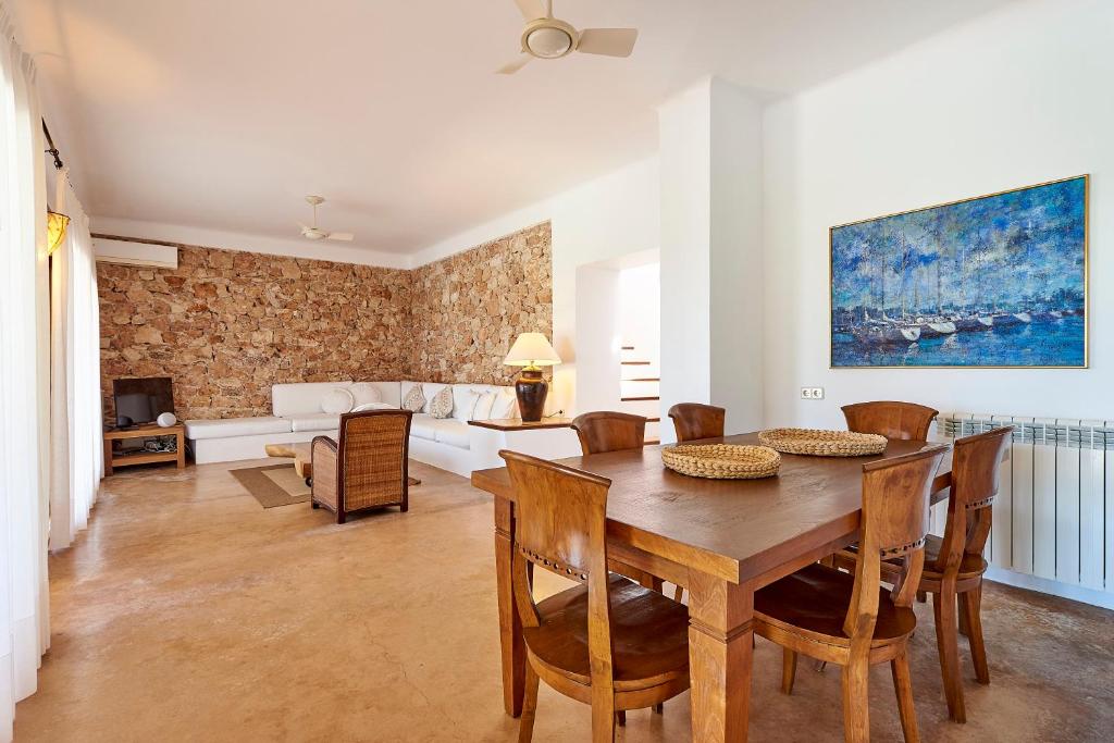 a living room with a wooden table and chairs at Can Mares in Cala Tarida