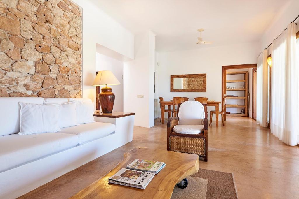 a living room with a white couch and a table at Can Mares in Cala Tarida