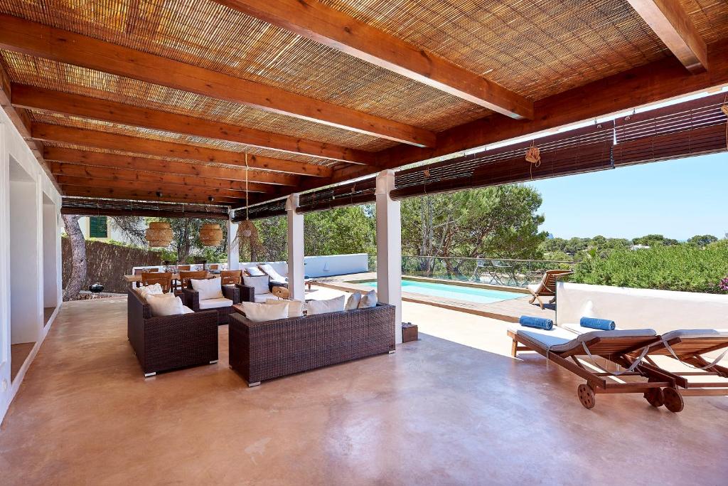 an outdoor living room with furniture and a swimming pool at Can Mares in Cala Tarida