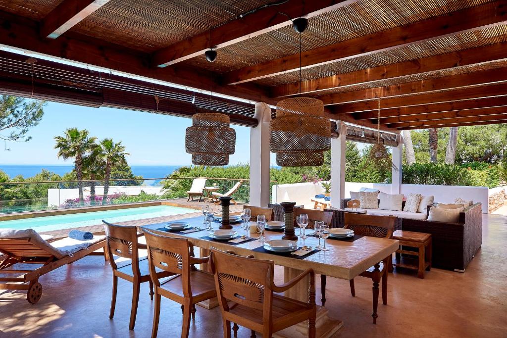 a dining room with a table and chairs and a couch at Can Mares in Cala Tarida