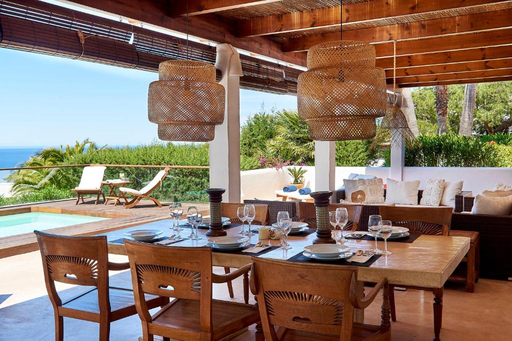 a dining room with a table and a view of the ocean at Can Mares in Cala Tarida