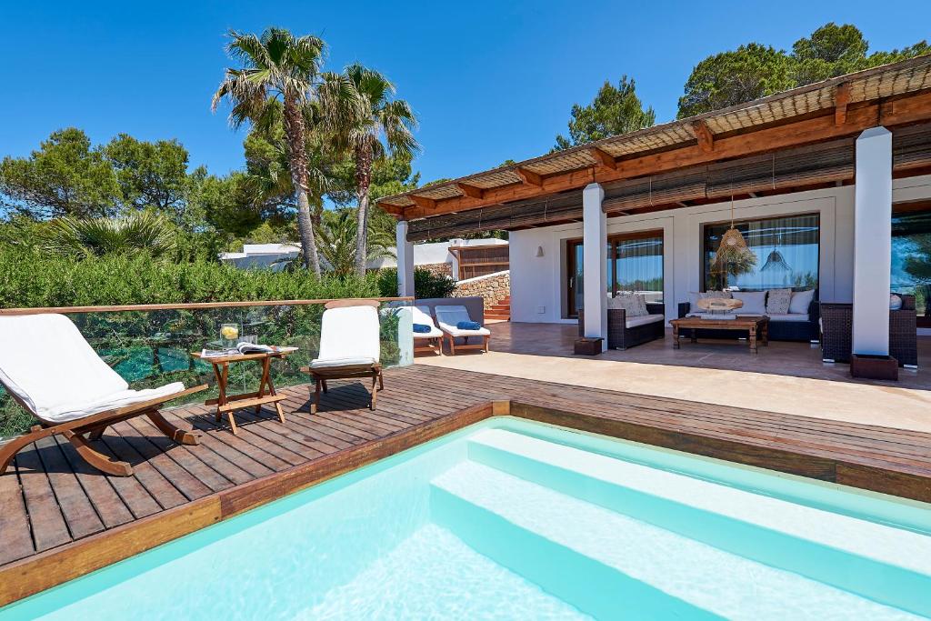a villa with a swimming pool and a house at Can Mares in Cala Tarida