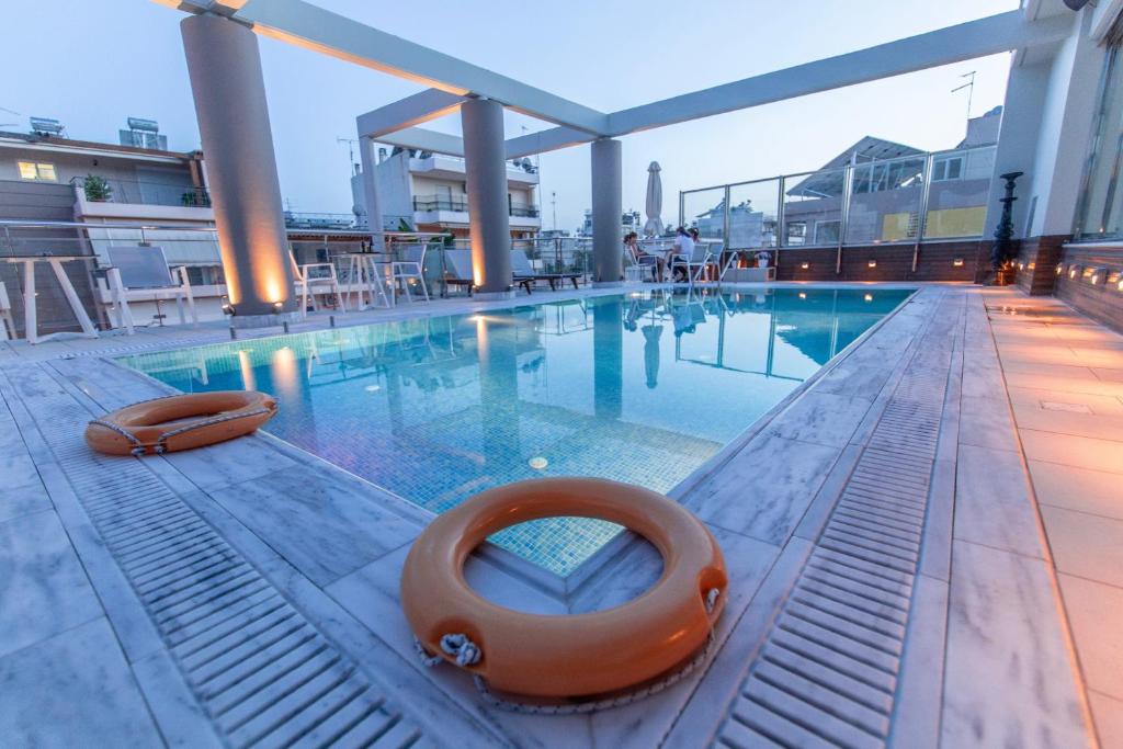 una piscina con una balsa naranja en el agua en Comfy Boutique Hotel en Kalamata