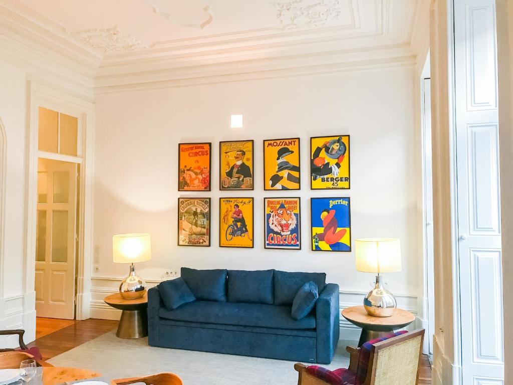 a blue couch in a living room with pictures on the wall at Downtown Colosseum Apartments in Porto