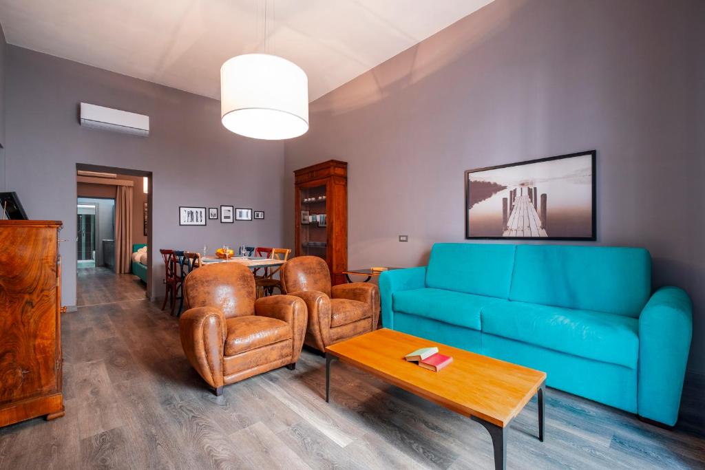 ein Wohnzimmer mit einem blauen Sofa und Stühlen in der Unterkunft Maison Degli Archi in Sorrent