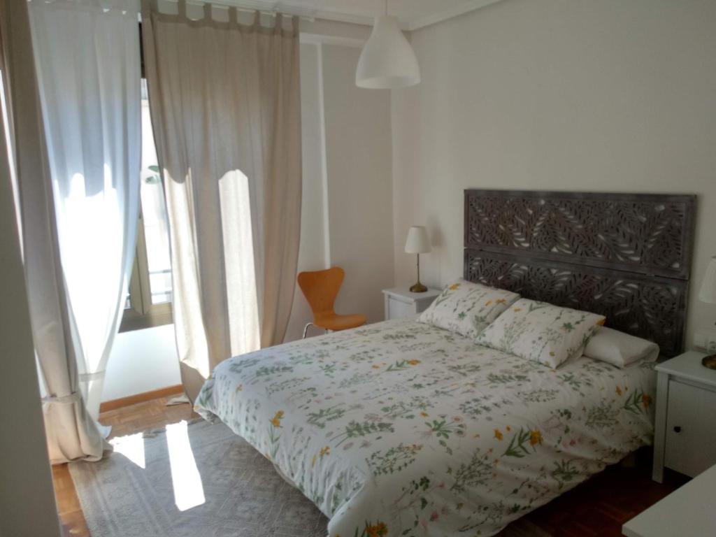 a bedroom with a large bed with a floral bedspread at KM0 CENTRO CIUDAD in Valencia