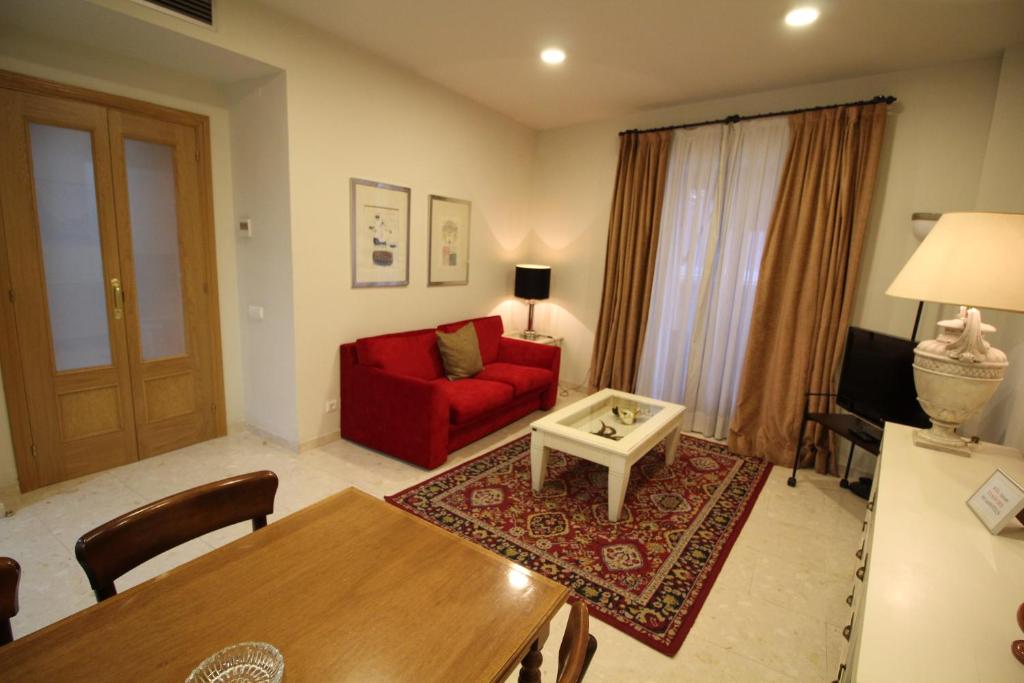 een woonkamer met een rode bank en een tafel bij Apartaments St. Jordi Comtal in Barcelona