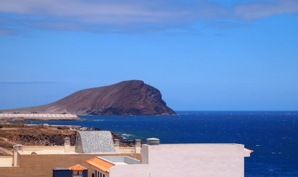 a view of the ocean with a mountain in the background at Plaza Vista Mar Dos in Los Abrigos
