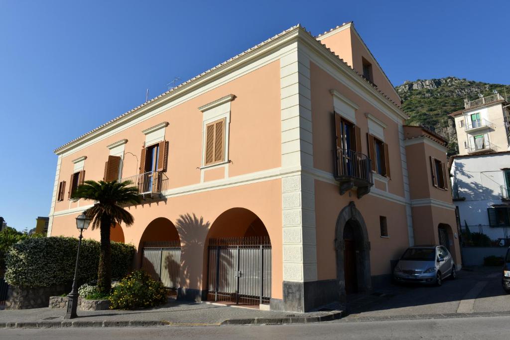 a building with a palm tree in front of it at Sorrento Coast Relais in Meta