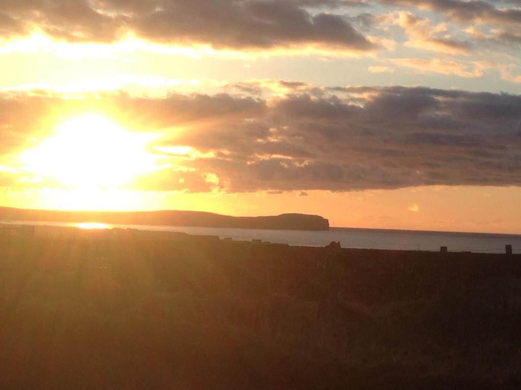 a sunset with the sun setting over the water at Creag Na Mara B&B in Thurso