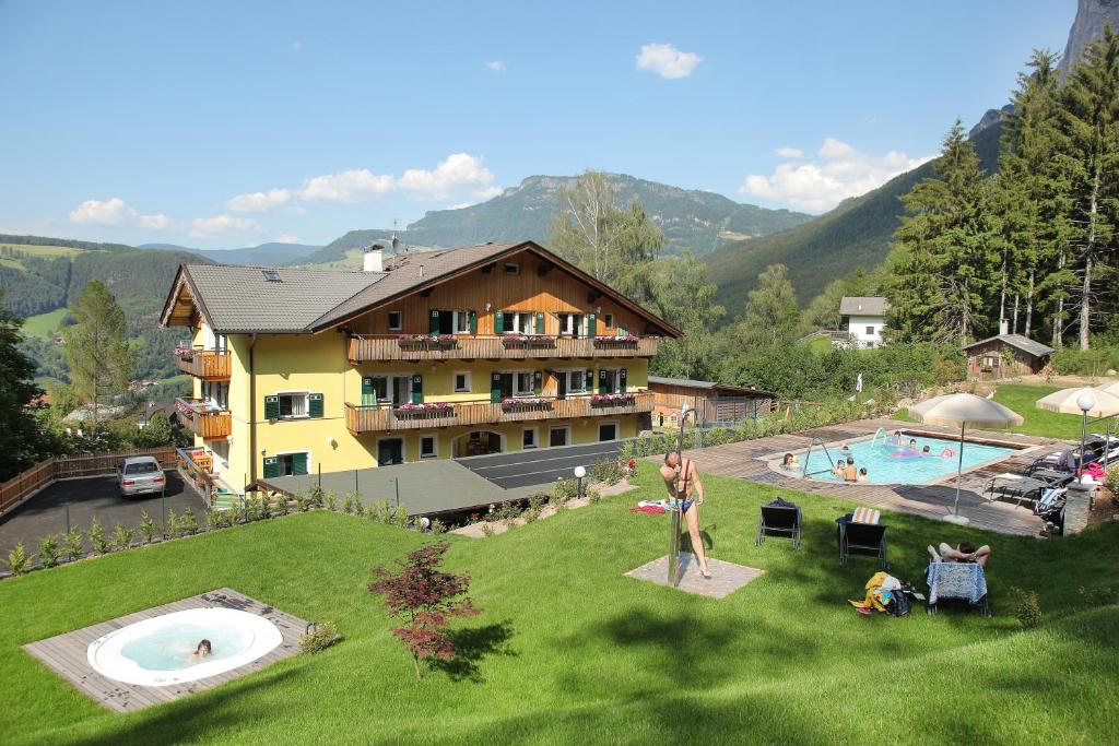 Eine Frau, die vor einem Resort im Gras steht. in der Unterkunft Residence St Konstantin in Völs am Schlern