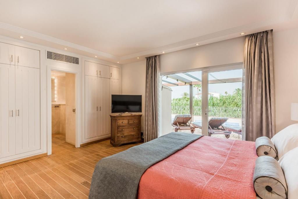 a bedroom with a large bed and a television at The Residence by the Beach House Marbella in Marbella