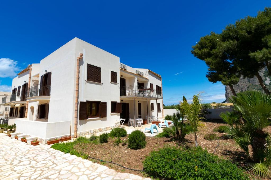 ein weißes Haus mit einem Baum und einer Auffahrt in der Unterkunft Boa Vista San Vito - Area Fitness, Barbecue Area, Tennis Court in San Vito lo Capo