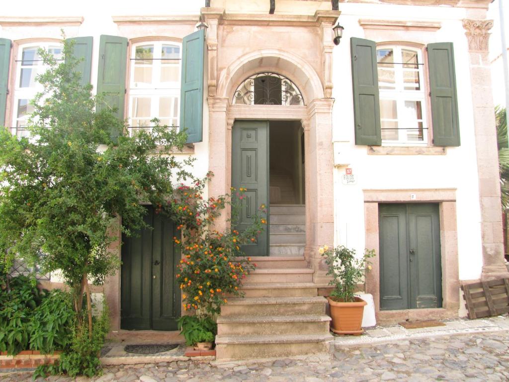 stary dom z zielonymi drzwiami i schodami w obiekcie Eolos House Cunda w mieście Ayvalık