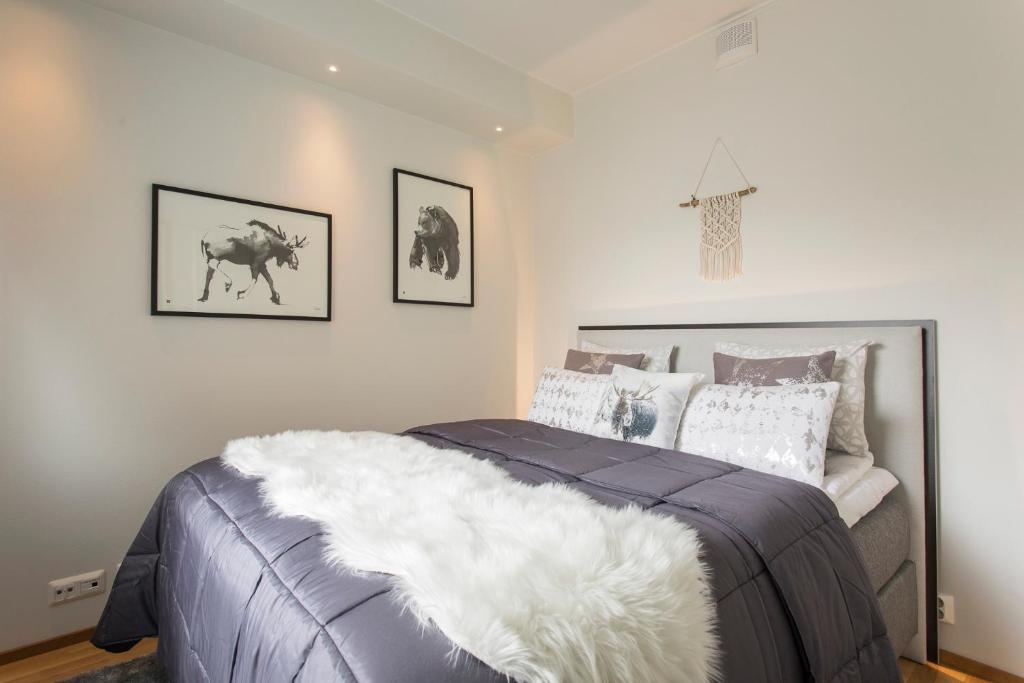 a bedroom with a bed with a white blanket at Vasko luxurious suites, Nouka in Rovaniemi