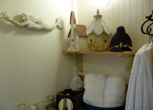 a room with a shelf with a bird house and towels at Magnolia Petal in Ganges