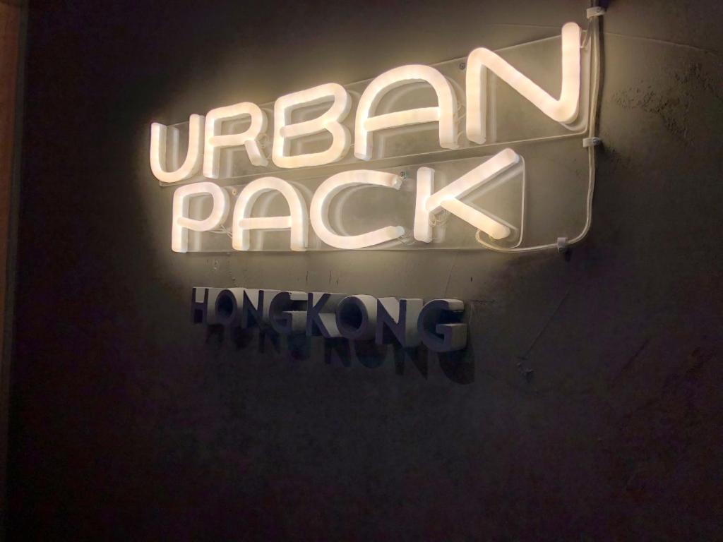 Un'insegna al neon che dice che una roccia urbana appesa a un muro di Urban Pack a Hong Kong