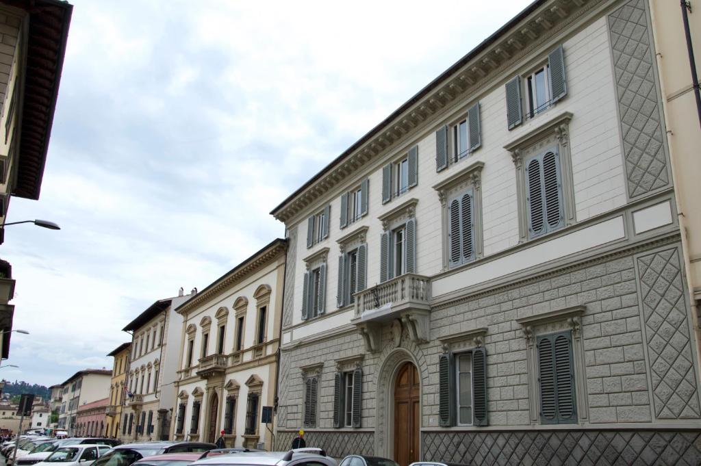 a large building with cars parked in a street at M&G Apartment in Florence