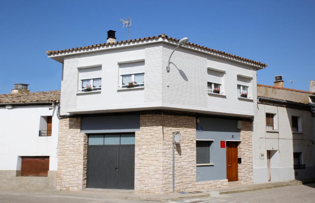 アルゲダスにあるApartamento La Noriaの窓とガレージのある白い家