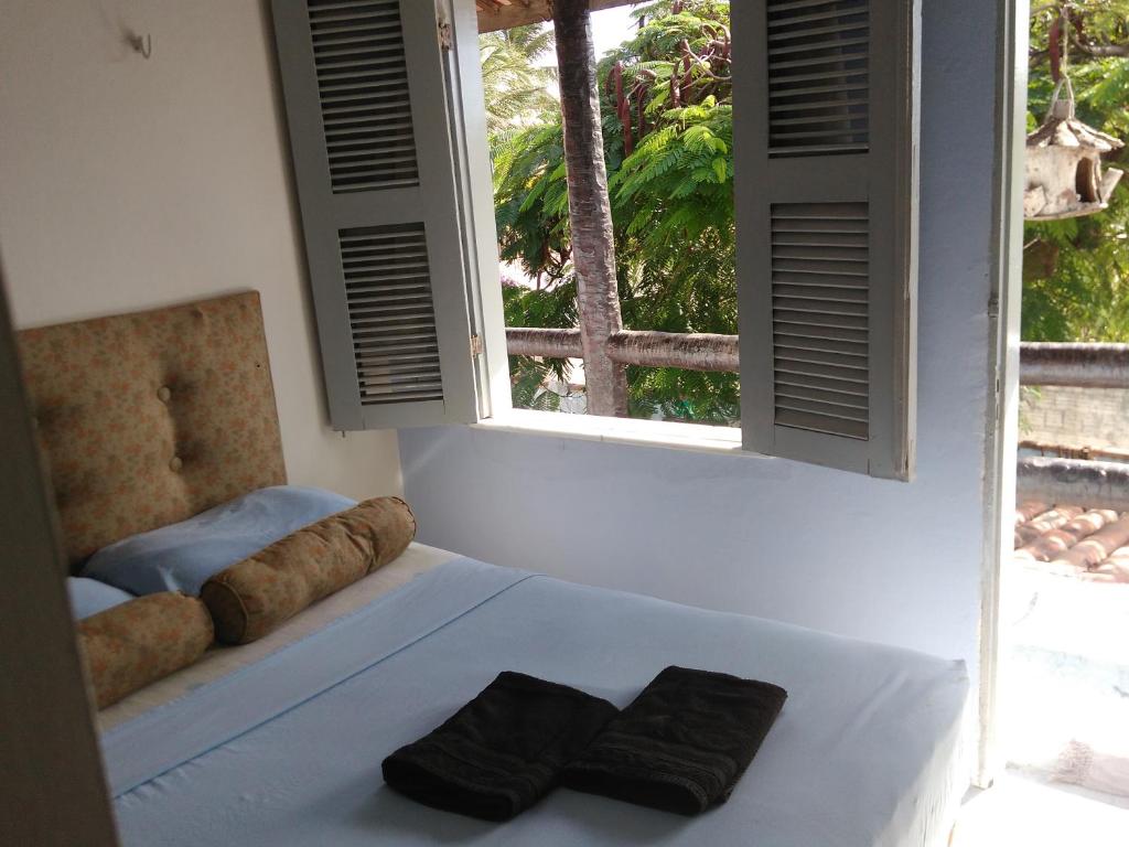 a bedroom with a bed with two black towels on it at Blue Day in Canoa Quebrada