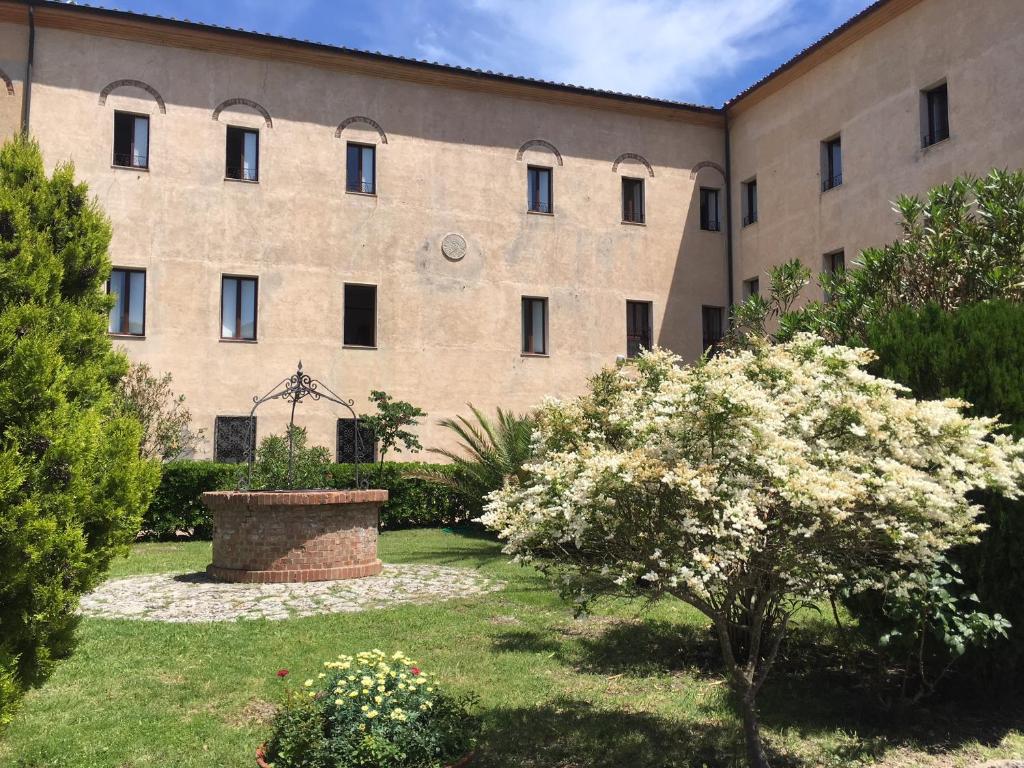 a large building with a garden in front of it at Casa Mater Ecclesiae in Massa Marittima