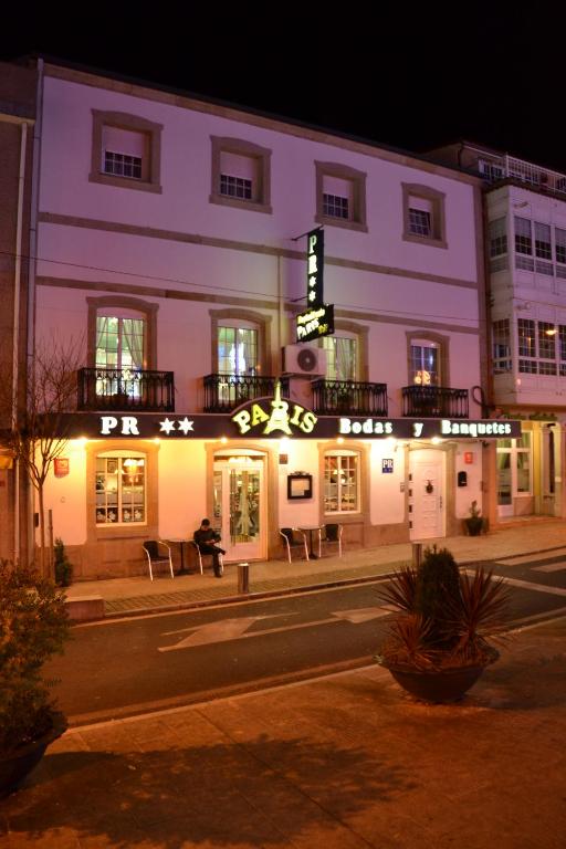 un edificio con un cartel en él por la noche en Hostal-Restaurante Paris, en Forcarei