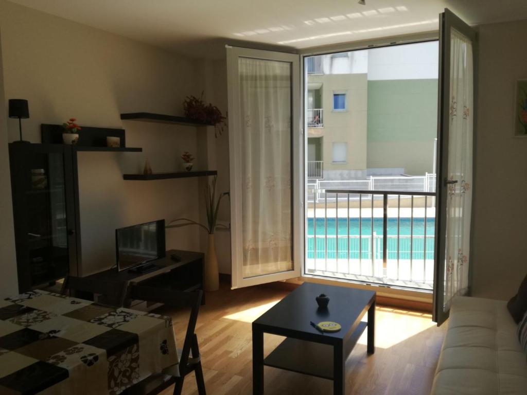 een woonkamer met uitzicht op een zwembad bij Apartamento Costa de Lugo in Foro