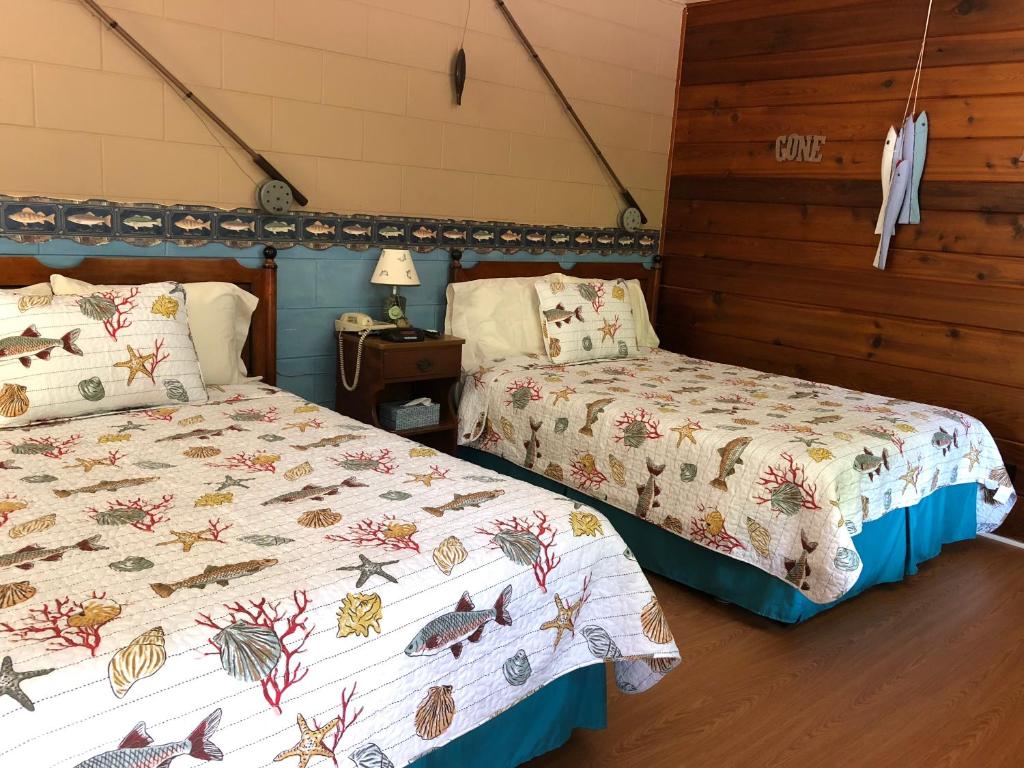 una camera con due letti e un tavolo con una lampada di Chateau Lodge a Oregon