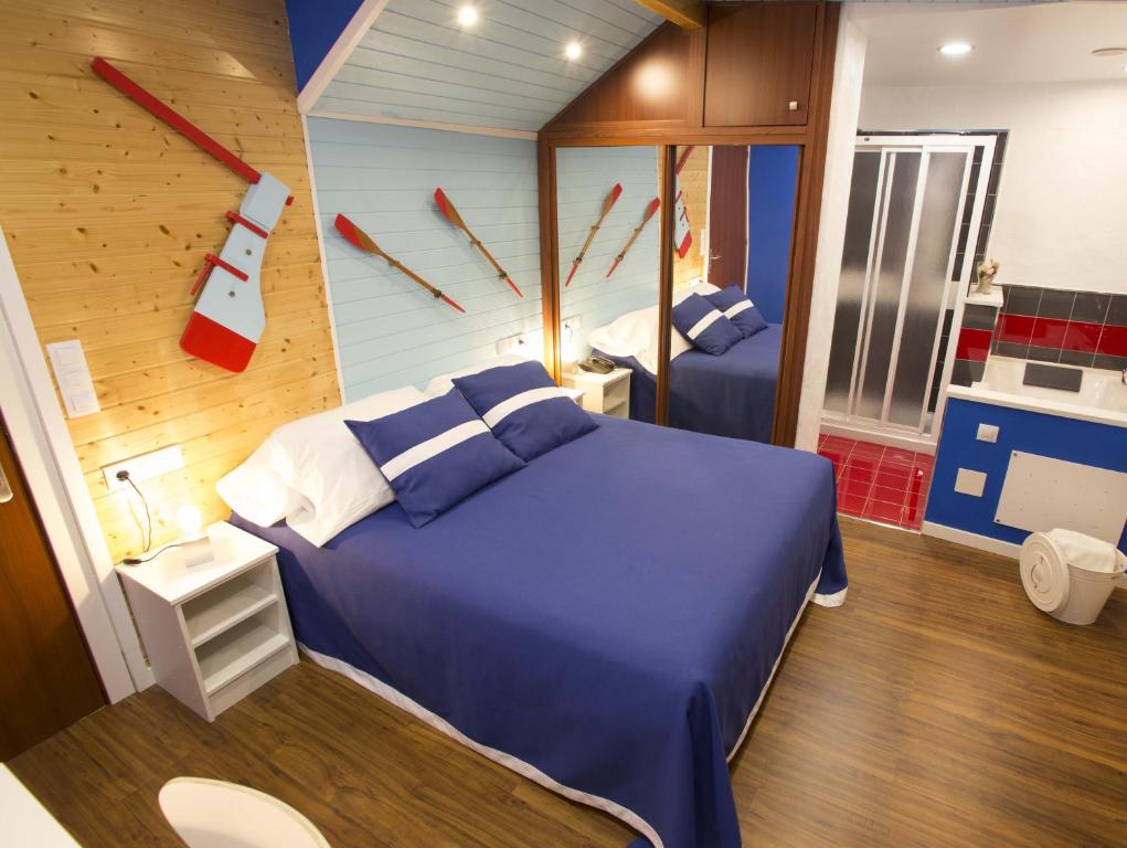a bedroom with a blue bed and a clock on the wall at Hotel A. G. Porcillan in Ribadeo
