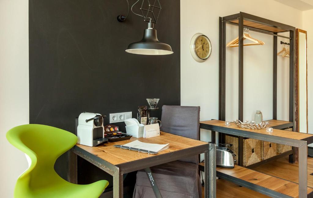 a dining room with a table and a green chair at Staycity Aparthotels Dresden City Centre in Dresden