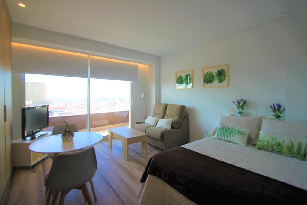 1 dormitorio con cama, sofá y mesa en CasaTuris Estudio con vistas que enamoran en Centro de Alicante A119, en Alicante