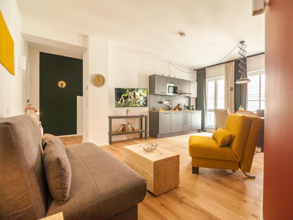 a living room with a couch and a chair at Staycity Aparthotels Dresden City Centre in Dresden