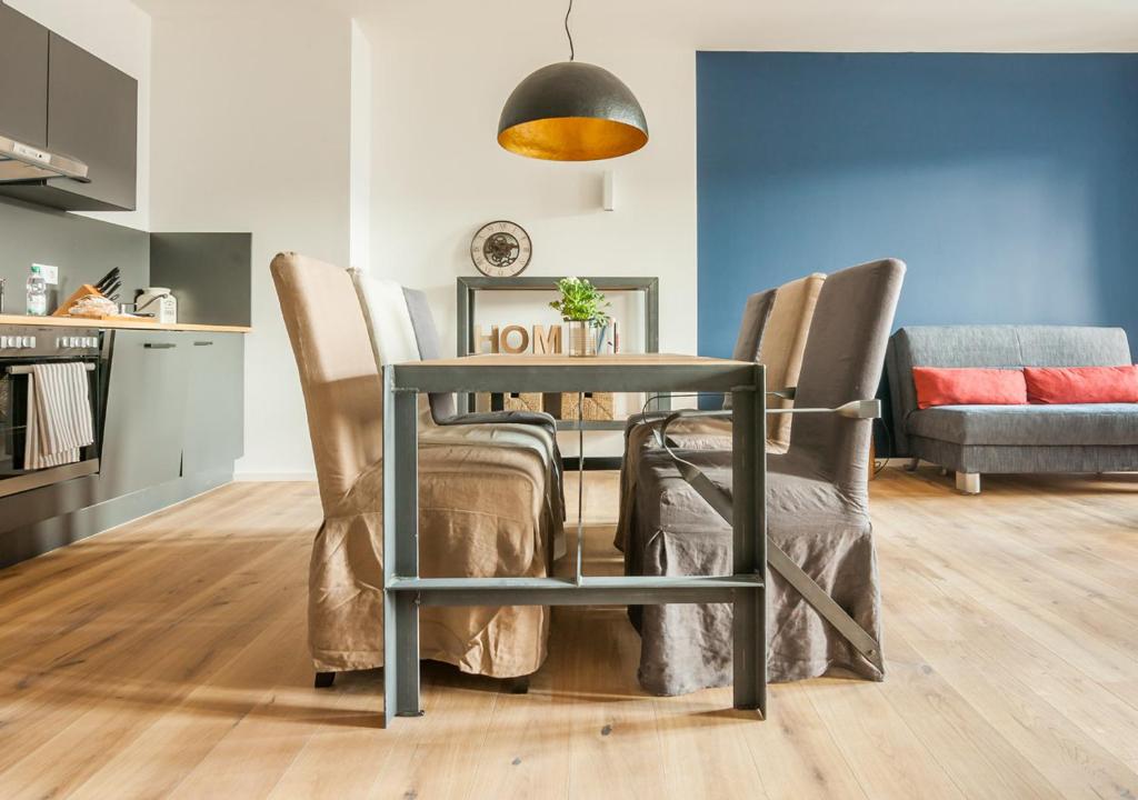 a dining room table with chairs and a lamp at Staycity Aparthotels Dresden City Centre in Dresden