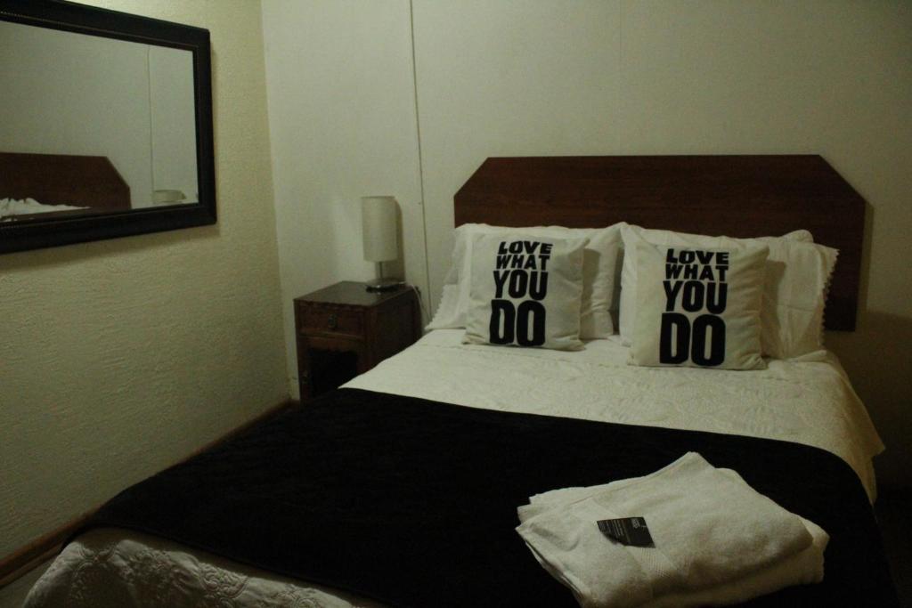 a bedroom with a bed with two pillows on it at Residencial del Maule in Linares