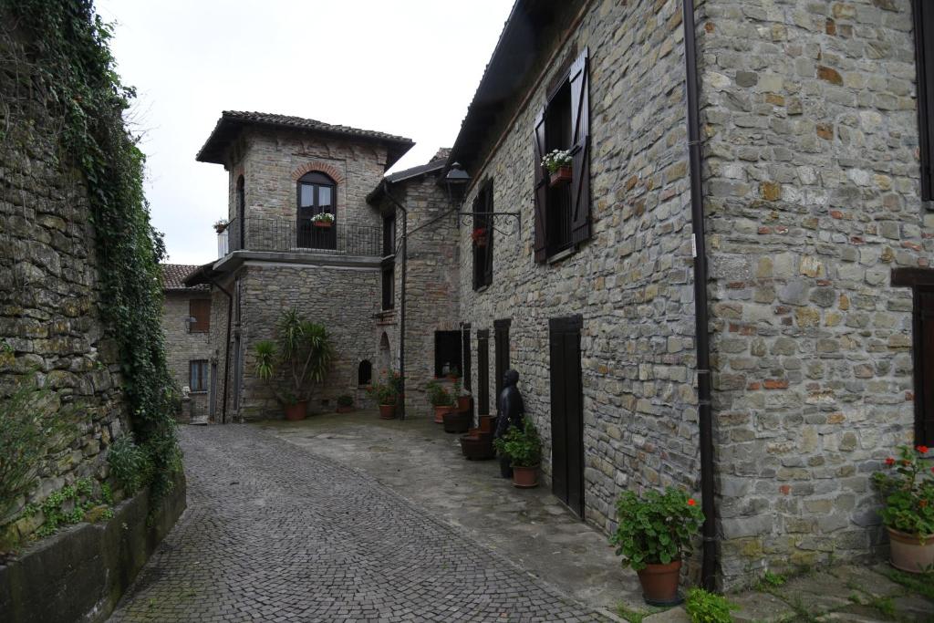 un callejón en un antiguo edificio de piedra con una persona de pie en la puerta en Il borgo, en Montabone