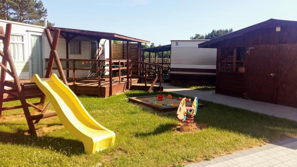 einen Hinterhof mit einem Spielplatz mit Rutsche in der Unterkunft Kalmar in Jastrzębia Góra