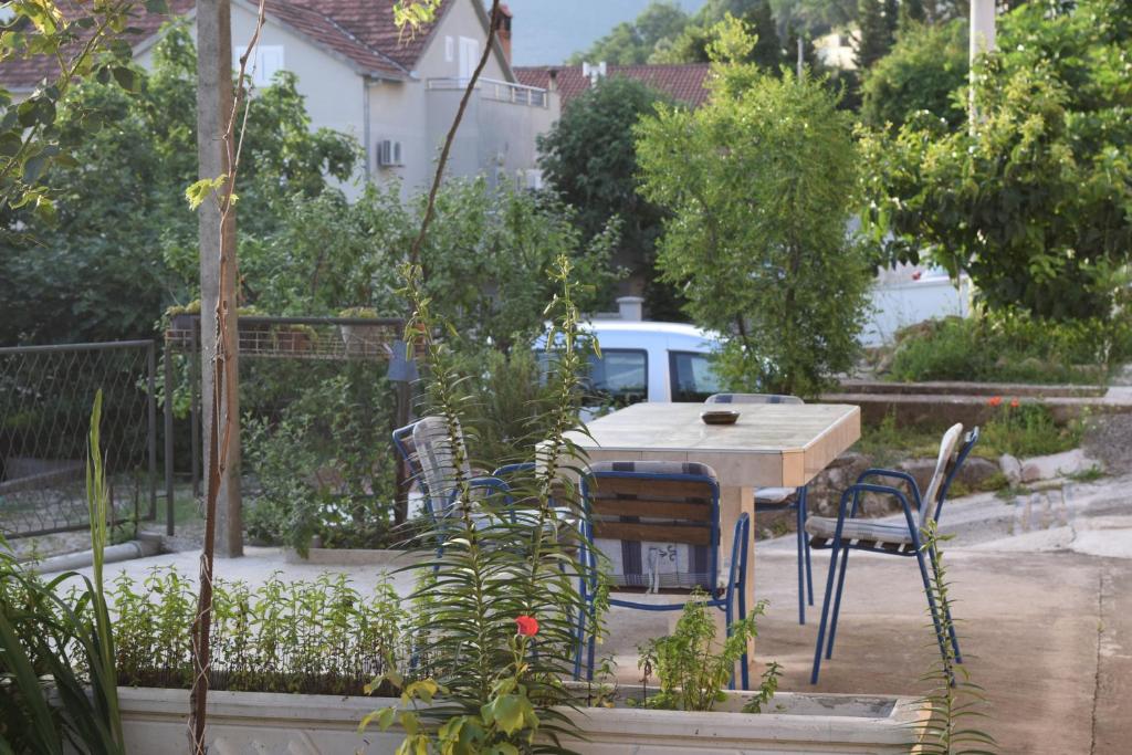 eine Terrasse mit einem Tisch und Stühlen im Garten in der Unterkunft Apartment S&M in Tivat