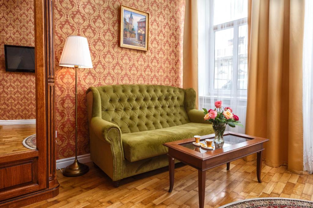ein Wohnzimmer mit einem grünen Sofa und einem Tisch in der Unterkunft Cozy Apartment 39/34 in Lwiw