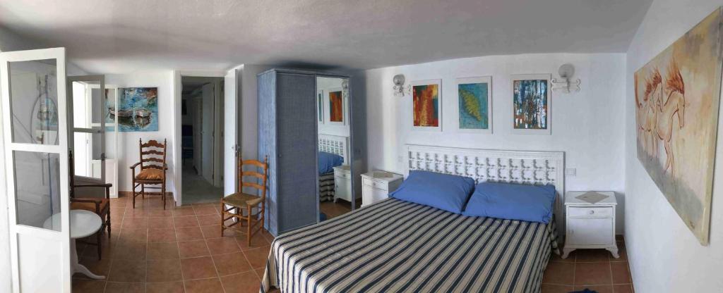 a bedroom with a bed with blue pillows on it at Hébergement front de mer in Sant Elm