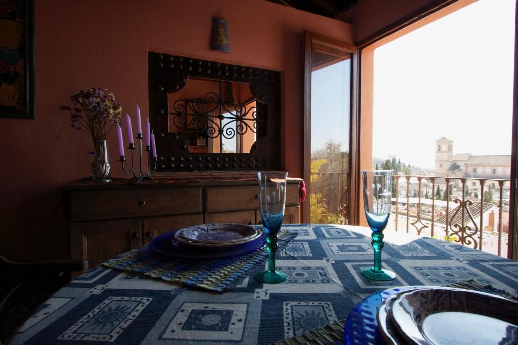 a table with a plate and two wine glasses on it at Apartamento Mirador de Soraya in Granada