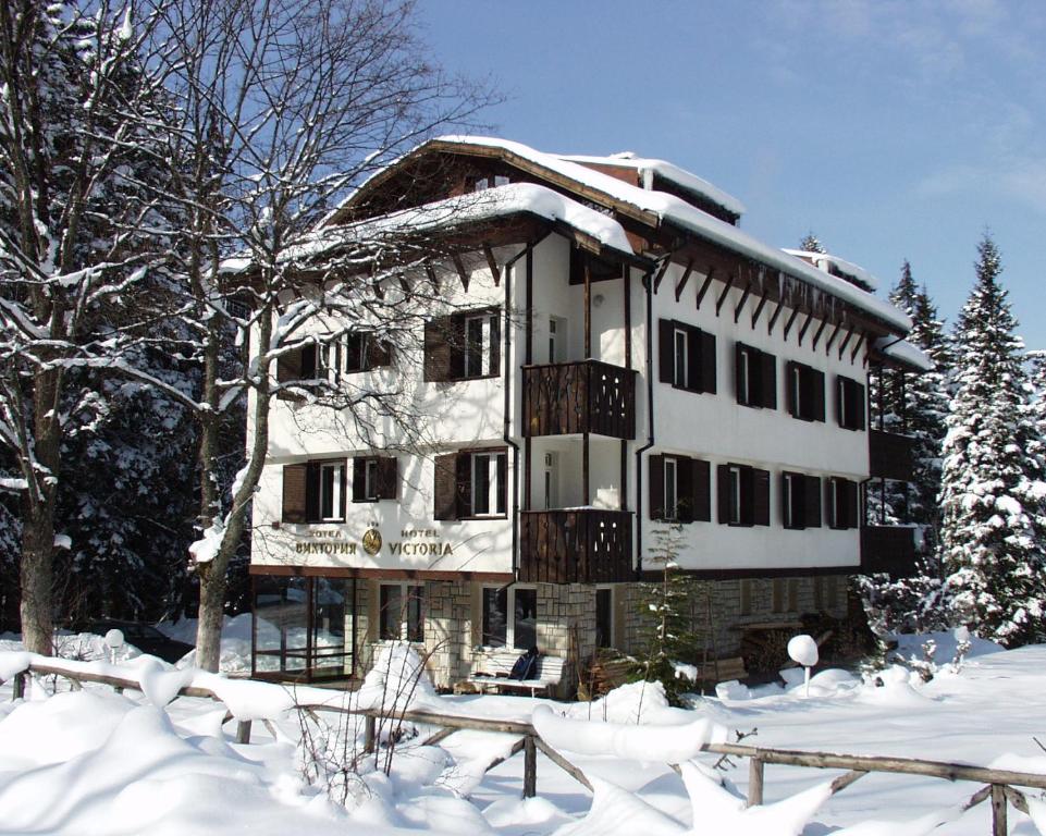 una casa cubierta de nieve en la nieve en Victoria Hotel Borovets - Free Parking, en Borovets