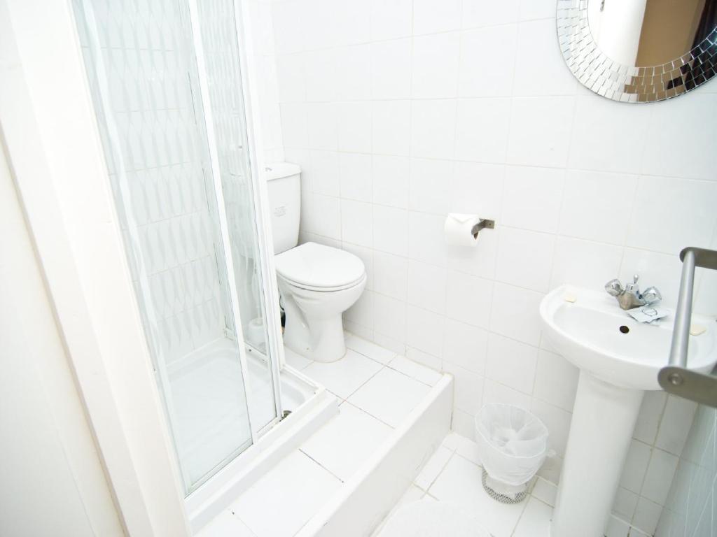 a white bathroom with a toilet and a sink at The Windmill Hotel in London